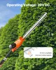 A close-up of a hedge trimmer with a large green hedge in the background. Produktbild-Vorschau