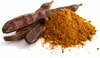 A pile of carob powder next to carob pods on a white background. Produktbild-Vorschau