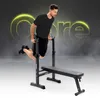 A man is performing dips on a dip station next to a flat bench. The word 'Core' is visible in the background. Náhled obrázku produktu