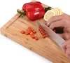 A person's hands are chopping red bell pepper on a bamboo cutting board. Sliced lemons and parsley are also visible. Náhled obrázku produktu