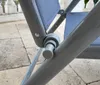 Close-up of the joint mechanism of a gray folding chair with blue fabric. Produktbild-Vorschau