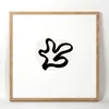 A framed abstract artwork with a black line drawing on a white background, set within a light wood frame. Produktbild-Vorschau