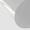 A close-up of a transparent PVC table protector with a gray circular object in the foreground. Produktbild-Vorschau
