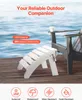 An Adirondack ottoman is placed on a wooden deck in front of a body of water, with a chair visible in the background. Voir les images du produit