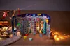 A Christmas-themed advent calendar in the shape of a building, decorated with festive imagery and lights. Voir les images du produit