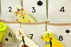 A close-up view of a fabric advent calendar with numbered pockets, featuring cartoon animal cutouts peeking out. Podgląd zdjęcia produktu