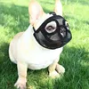 A French Bulldog wearing a black mesh muzzle sits on green grass. Produktbild-Vorschau
