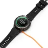 A close-up shot of a smartwatch connected to an orange charging cable, with the watch face displaying the time and charging status. Produktbild-Vorschau
