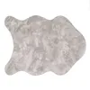 A single, irregularly shaped rug with a textured, mottled gray surface, presented on a white background. Produktbild-Vorschau