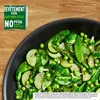 A close-up of a pan filled with cooked green vegetables on a wooden surface. Voir les images du produit