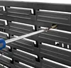 A close-up of a black plastic storage system with a screwdriver being used to attach it. Náhled obrázku produktu