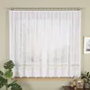 A white lace curtain hangs in front of a window, with plants and decorative items on the windowsill. Náhled obrázku produktu
