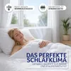 A woman sleeping peacefully under a duvet, with sunlight streaming through a window. Produktbild-Vorschau