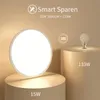 A modern LED ceiling light is shown on a pedestal, with text comparing its energy efficiency to a traditional light bulb. Produktbild-Vorschau