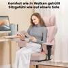 A woman is sitting in a pink gaming chair and reading a book. Podgląd zdjęcia produktu