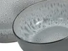 A close-up view of a grey ceramic bowl with a speckled pattern and a white, marbled interior. Produktbild-Vorschau