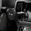 A car's interior with a BMW branded wireless car charger mounted on the dashboard. Podgląd zdjęcia produktu