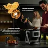 People enjoying food and drinks in a modern kitchen setting. Podgląd zdjęcia produktu