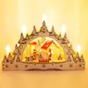 A wooden Christmas decoration with a village scene and LED candles. Produktbild-Vorschau