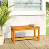 A wooden bench is placed on a wooden deck next to a potted plant, with a white wall and window in the background. Náhled obrázku produktu