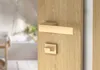 A close-up of a wooden door with a gold-colored door handle and lock mechanism. Produktbild-Vorschau