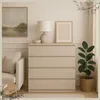 A modern bedroom or living room setting with a chest of drawers, sofa, lamp, and plant. Produktbild-Vorschau