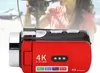 A red 4K video camera is shown in the foreground, with a blurred image of a person holding a larger camera in the background. Podgląd zdjęcia produktu