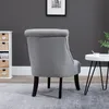 A grey armchair is shown from the back in a room with a dark grey wall and a small white side table. Voir les images du produit