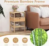 A bamboo nightstand with a drawer and shelves, placed next to a brown sofa. The image also features decorative elements like flowers and a vintage radio, along with marketing text and icons. Podgląd zdjęcia produktu
