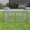 A wire mesh enclosure for small animals is placed on a grassy lawn in front of a modern garden setting with large stones and plants. Anteprima dell’immagine prodotto