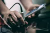 A close-up shot of a person's hands holding a device and a cable. Podgląd zdjęcia produktu