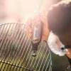 A person is using a Dremel tool to clean a grill. Produktbild-Vorschau