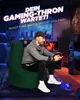 A man is playing video games while sitting on a large green beanbag chair in a dimly lit room with gaming equipment. Produktbild-Vorschau