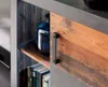 A close-up of a shelf in a modern furniture piece, showing a blue vase and books. Produktbild-Vorschau