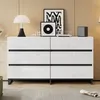 A white dresser with six drawers is displayed in a room with wood-paneled walls and a striped rug. Produktbild-Vorschau
