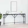 A long, narrow black console table against a white wall, with a framed picture above it and some decorative items on top. Náhled obrázku produktu