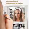 A woman is applying makeup in front of a mirrored jewelry cabinet. Voir les images du produit