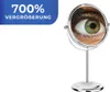 A close-up of a human eye reflected in a magnifying mirror, with a text overlay indicating 700% magnification. Produktbild-Vorschau