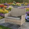 A polyrattan garden bench with a grey cushion is placed on a patio in a garden with colorful flowers. Anteprima dell’immagine prodotto
