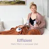 A woman is sitting on a couch, using a breast pump. Produktbild-Vorschau