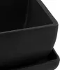 A close-up view of a black ceramic planter with a saucer. Produktbild-Vorschau