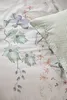 A close-up view of a floral patterned duvet cover and a textured pillow. Produktbild-Vorschau