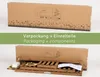 The image shows a cardboard box with a decorative border of wildflowers, and below it, the contents of the box, including wooden shelves and assembly instructions. Produktbild-Vorschau