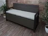A poly-rattan storage bench with a gray cushion is shown in an indoor setting with wooden walls and flooring. Náhled obrázku produktu