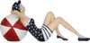 A decorative figurine of a woman in a vintage swimsuit lying on a beach ball. Anteprima dell’immagine prodotto