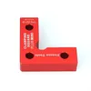 A red L-shaped clamping square with text on it, isolated on a white background. Náhled obrázku produktu