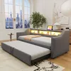 A modern living room with a grey sofa bed pulled out, featuring integrated LED lighting and a tablet. Voir les images du produit