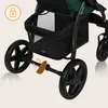 Close-up view of the lower part of a stroller, focusing on the wheels and basket. Náhled obrázku produktu