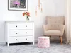A cozy living room corner with a dresser, armchair, and ottoman. Produktbild-Vorschau