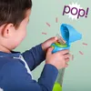 A young child is holding and opening a colorful sippy cup with a straw. Náhled obrázku produktu